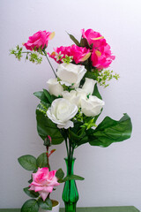 vase with pink flowers and green leaf.
