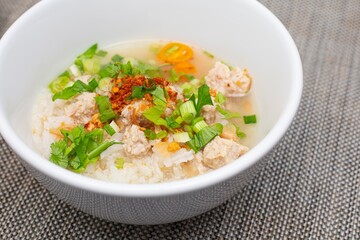 Rice porridge with minced chicken, serving in white bowl. Ready to eat. Traditional Thai food in the morning.   