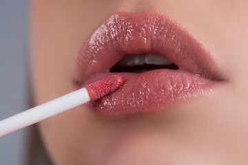 Nude makeup beauty. Lips lipstick closeup. Applying make up on lip. Pampering, lips correction...