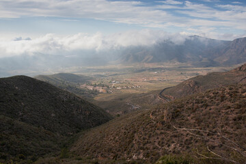 Valley between mountains under a cloudy sky.