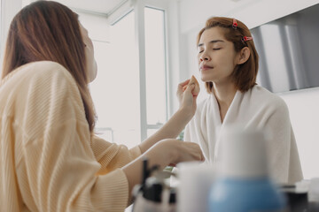 Fototapeta premium Asian woman is wearing makeup by the makeup artist.