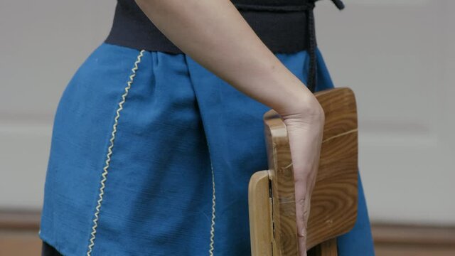 woman's hand touching carefully a chair made of wood