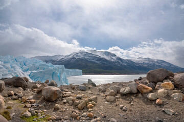 Paisaje con Glaciar Perito Moreno, cielo con nueves a orillas del lago en una playa con piedras