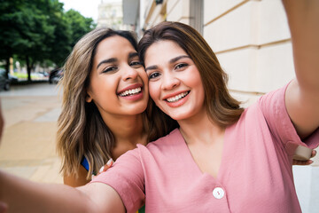 Two friends taking a selfie outdoors.