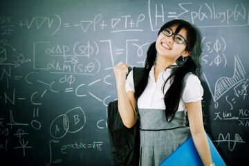 Female student expressing happy near math formulas