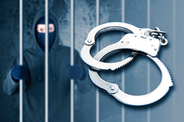 Silver handcuffs with arrested hacker in prison