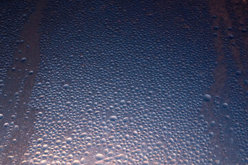 winter background of frozen ice window glass at sunset background.