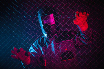 Welder in the neon lights in the welding helmet.
