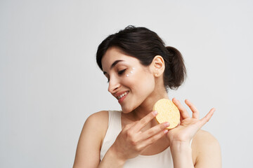 Beautiful brunette holding a sponge in her hands clean health skin close-up