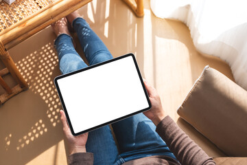 Top view mockup image of a woman holding and using tablet pc with blank desktop white screen at home
