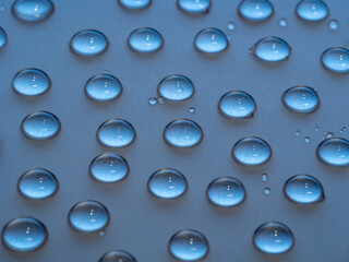 Bright water drops on the light brown surface