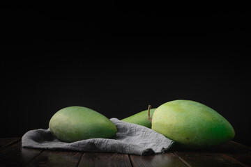 Fresh green mango against a dark background