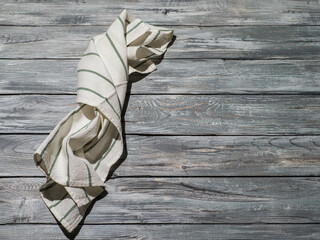 Wooden background with linen kitchen towel or textile napkin.