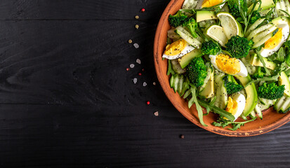 Healthy food. Fresh green salad on black background, Long banner format. Food recipe background. Close up. top view