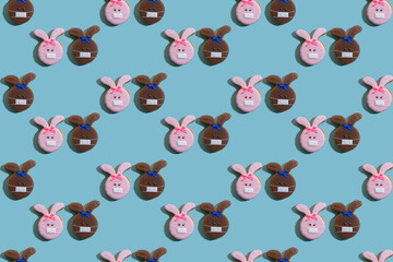 Pandemic background. Seamless pattern. Social distancing. Covid-19 lockdown. Cute pink brown bunny couple in protective face mask creative minimal symmetrical design isolated on blue abstract poster.