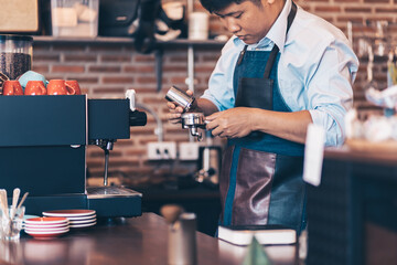 Barista heats milk steam for making lattes at coffee shop.