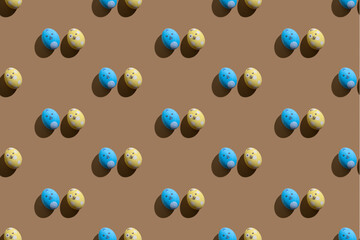 Bunny abstract pattern. Seamless background. Cute ornament for kids. Blue yellow painted Easter egg couple with rabbit design minimal composition isolated on brown beige wallpaper for boy or girl.