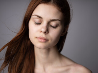Obraz premium portrait of a beautiful woman close-up red hair gray background Mode