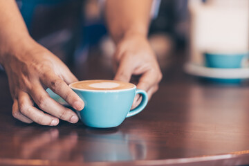 Barista serving a coffee to customer at the coffee shop.