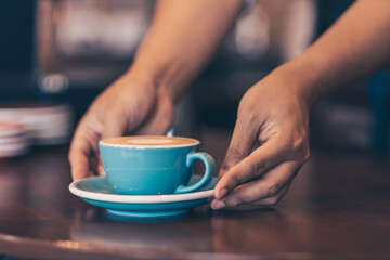 Barista serving a coffee to customer at the coffee shop.