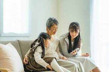 スマートフォンを見るシニア女性と孫