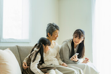 スマートフォンを見るシニア女性と孫