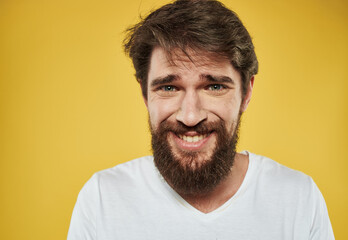 Fototapeta premium Emotional man with thick beard grinning model yellow background