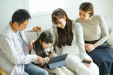 タブレットPCを見る日本人家族 © arc image gallery