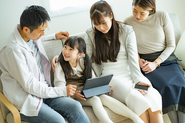 タブレットPCを見る日本人家族 © arc image gallery