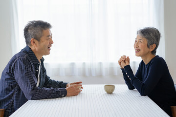 向き合って会話する日本人シニア夫婦