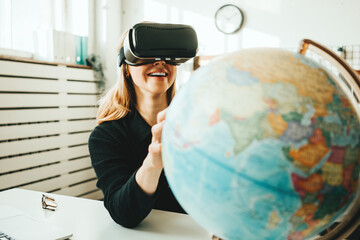 Smiling handsome woman wearing vr headset and virtual travel with world globe