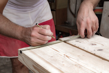 Male carpenter working with wood material in a garage.