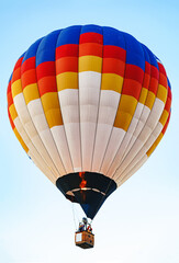 Multicolored air balloon in clear blue sky