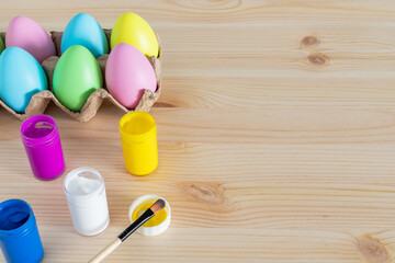 Easter eggs and colored paints on the table for holiday craft.