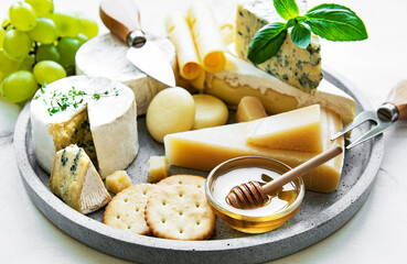 Various types of cheese, grapes and honey