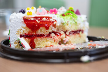 Selective focus knife cut cake cream on dish.Birthday cake in the family party.Unhealthy and fat food concept.