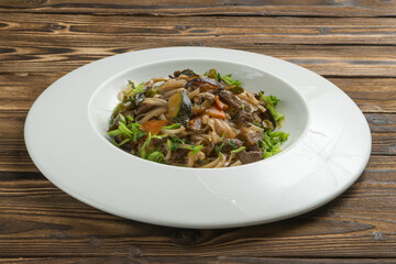 Chinese rice noodles wok with beef, vegetables and green onions.