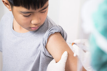 Doctor's hand injecting for vaccination in the shoulder kid patient.Vaccine for protection...