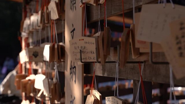 Slow close up rotating shot of wooden wishing cards at Japanese Shrine