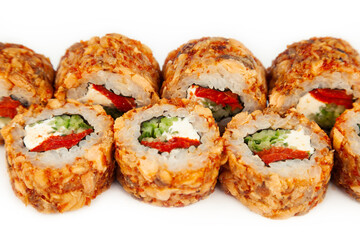 Sushi Roll with fried salmon in Teriyaki sauce on a white plate, ingredients Fried salmon, cream cheese, cucumber, baked pepper, flying fish roe, Spicy sauce, rice, nori. For the restaurant menu.
