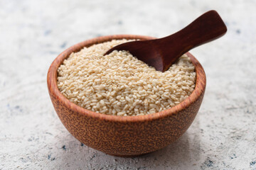 
Healthy sesame seeds in a wooden bowl on a white background.