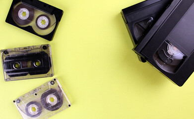Three audio tapes and two video tapes on a yellow background. Retro technology