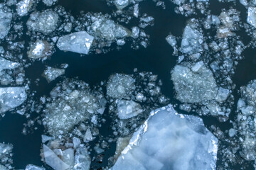 Abstract winter nature background. Top view of ice drift on Moscow river, Russia. Ice floes of different sizes floats on the water. Springtime theme. © Андрей Рыков