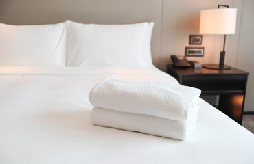 Clean white bath towels on the neatly clean bed with - coziness and clean concept