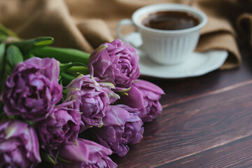 Spring flowers. Bouquet of tulips on a wooden background. Coffee and tulips. Flatley.