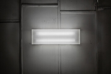 Bottom-up view of a fluorescent lamp on the ceiling in a decorative plastic box with a metal...