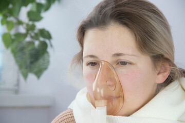 portrait of a young woman inhaling medicines for bronchitis and asthma at home