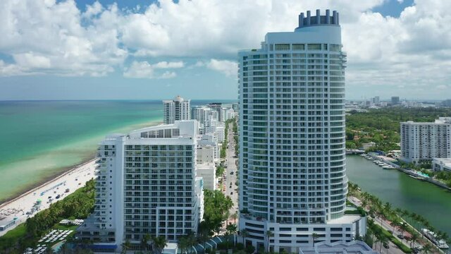 Scenic modern architecture white buildings of luxury resorts and hotels on Atlantic beach with ocean view. USA travel, vacation 4K. Miami beach aerial panorama. Coastal cityscape on sunny summer day