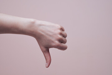 Female hand showing thumb down gesture. Hand signs communication concept. Closeup, copy space