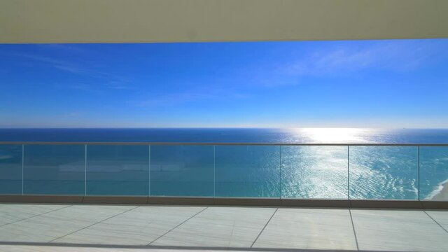 Exit to the terrace overlooking the ocean. View of the ocean and clear sky. Luxury living.